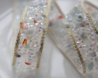 May include: White trim ribbon with iridescent crystals and gold thread. The ribbon is a decorative trim for crafts and sewing projects.