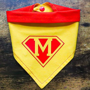 May include: Yellow and red dog bandana with a red Superman logo and the letter "M" in the center.