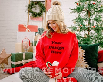 May include: A woman wearing a red sweatshirt with the text "Your Design Here" in black. She is holding a mug with a candy cane and is sitting in front of a Christmas tree.