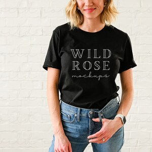 以下が含まれることがあります： 前面に白い文字で「WILD ROSE mockups」とプリントされた黒いTシャツです。