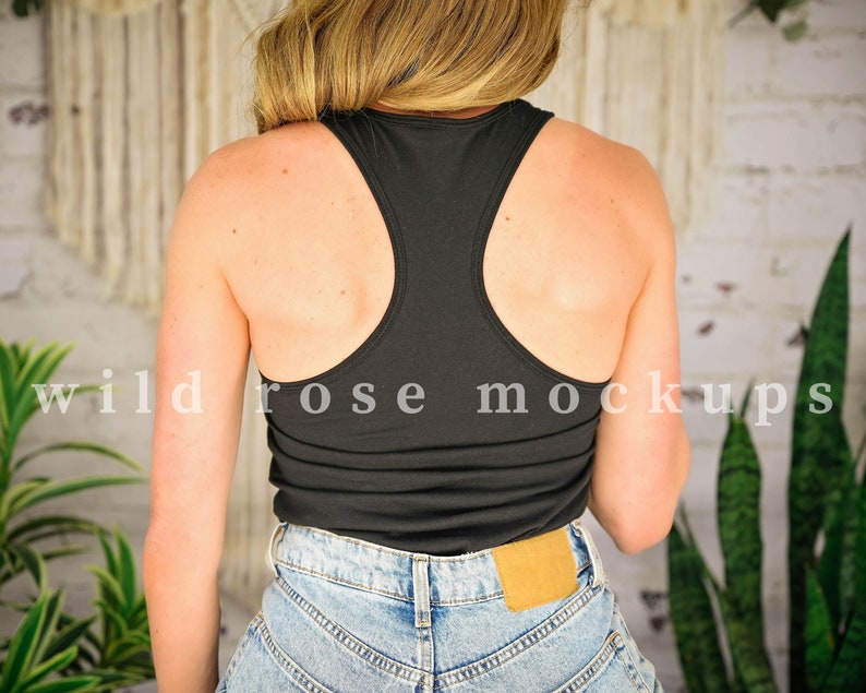 May include: A black racerback tank top with a scoop neck. The tank top is made of a soft, stretchy fabric and is perfect for layering or wearing on its own.