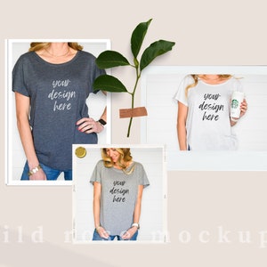 May include: Three t-shirts in dark gray, white, and light gray, each featuring the text 'your design here' in a script font. The shirts have short sleeves and a scoop neckline. A green leafy branch is positioned between the shirt images.