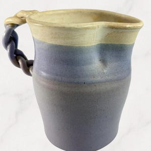 Jarra de crema de cerámica artesanal de gres azul beige con asa trenzada y maceta.