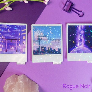 Puede incluir: Tres pegatinas hologr&aacute;ficas con un esquema de color morado y azul. Las pegatinas presentan una ciudad con una luna creciente, un cielo nocturno estrellado y una galaxia con una nebulosa giratoria.