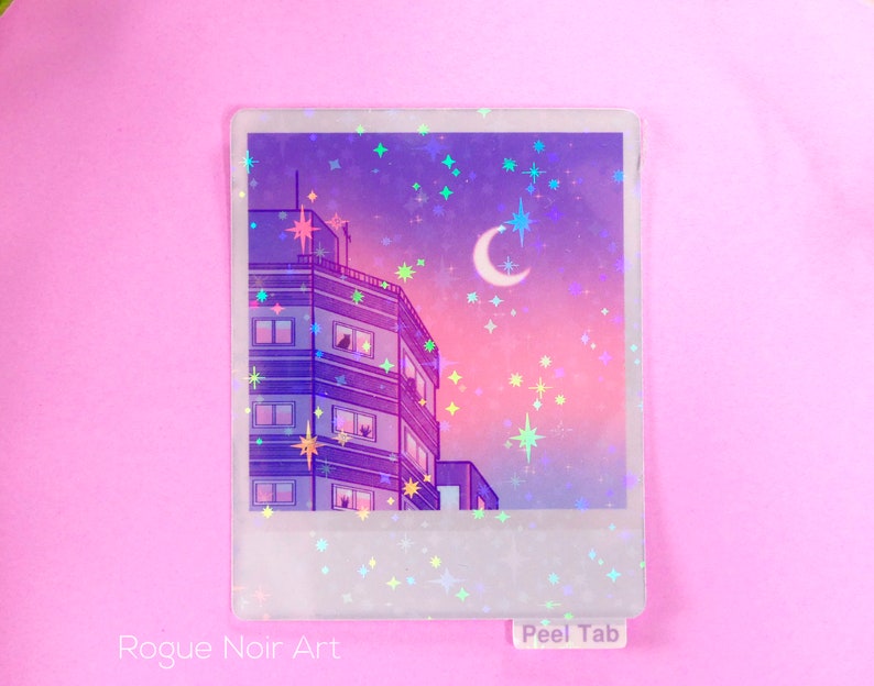 May include: A holographic sticker featuring a purple and pink cityscape with a crescent moon and stars. The sticker has a white border and the text "Peel Tab" at the bottom.