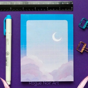 May include: A blue and white sticker with a crescent moon and clouds. The sticker has a grid pattern and the text "Rogue Noir Art" at the bottom.