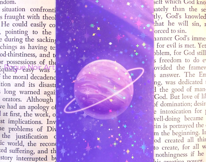 May include: A purple planet with a ring around it, surrounded by a purple and blue galaxy with white stars. The planet has a light purple and white swirl pattern.