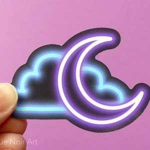May include: A sticker with a neon blue cloud and a purple crescent moon. The sticker is on a pink background.
