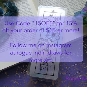 May include: A bookmark with a floral design in black and white. The bookmark is on a purple background with gold stars. The text on the bookmark reads "Use Code "15OFF" for 15% off your order of $15 or more! Follow me on Instagram at rogue_noir_draws for more art. Rogue Noir Art"