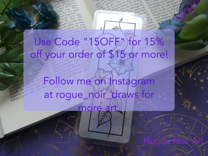 May include: A bookmark with a floral design in black and white. The bookmark is on a purple background with gold stars. The text on the bookmark reads "Use Code "15OFF" for 15% off your order of $15 or more! Follow me on Instagram at rogue_noir_draws for more art. Rogue Noir Art"