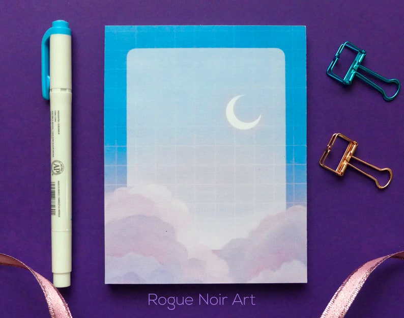 May include: A blue and white gridded notecard with a crescent moon and clouds in a pastel blue and purple colour scheme. The text "Rogue Noir Art" is printed at the bottom of the card.
