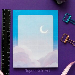 May include: A blue and white printable card with a crescent moon and clouds. The card has a grid pattern and the text "Rogue Noir Art" at the bottom.