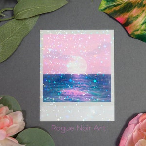 May include: A pink and blue sunset with a full moon and stars over a blue ocean. The image is a digital illustration with a glittery effect. The text "Rogue Noir Art" is at the bottom of the image.