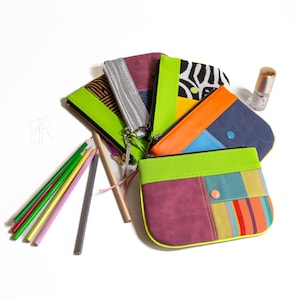 Peut inclure: Un ensemble de six pochettes zippées colorées avec différents motifs, dont des rayures, un imprimé zèbre et des motifs géométriques. Les pochettes sont en tissu et ont une bordure vert lime. Les pochettes sont disposées en éventail sur une surface blanche.