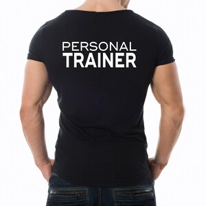 K&ouml;nnte beinhalten: Ein schwarzes T-Shirt mit dem Text "PERSONAL TRAINER" in wei&szlig; auf dem R&uuml;cken.
