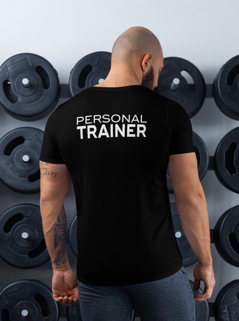 K&ouml;nnte beinhalten: Ein schwarzes T-Shirt mit dem Text "PERSONAL TRAINER" in wei&szlig; auf der R&uuml;ckseite.
