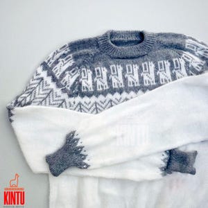 Pode incluir: Camisola de malha branca e cinzenta com um padrão de lhama. A camisola tem um decote redondo e mangas compridas.