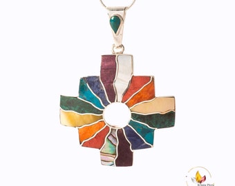 May include: A silver pendant necklace with a colorful, multi-stone cross pendant. The cross is made of various stones, including turquoise, lapis lazuli, and abalone shell. The pendant has a circular opening in the center.