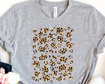 May include: A light grey heather t-shirt featuring a leopard print design. The shirt is made from a soft, comfortable material and has a relaxed fit.