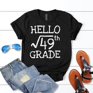 May include: Black t-shirt with white text that reads "Hello √49th Grade".