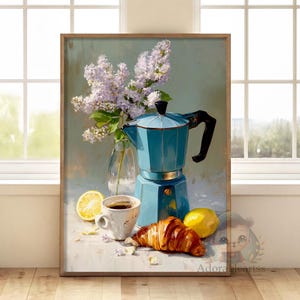May include: A framed still life painting depicting a blue coffee maker, a cup of coffee, a croissant, and lemons. A vase of lilac flowers is on the left. The painting has a soft, painterly style with a light colour palette.