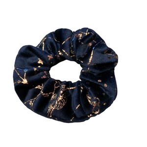 May include: A black velvet scrunchie with a gold constellation print.