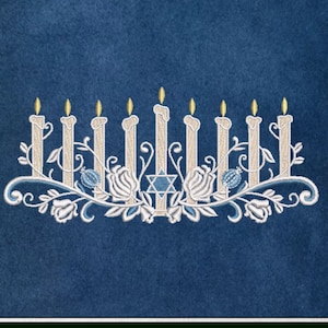 May include: A white embroidered design of a menorah with nine candles, a Star of David, and floral accents on a blue background. The text "Carrie Ellen Designs" is at the bottom of the image.