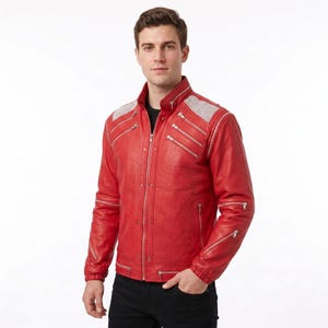 May include: A vibrant red leather jacket featuring a stand-up collar, multiple silver-toned diagonal zippers across the chest and sleeves, and white mesh paneling on the shoulders. The jacket includes a central zipper closure and elastic cuffs.