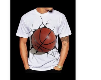 May include: White t-shirt with a graphic of a basketball breaking through the fabric. The basketball is brown and black.