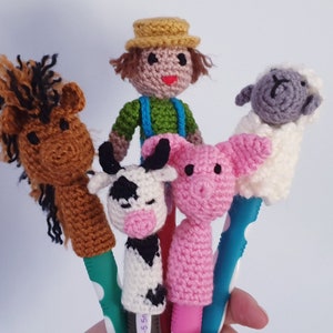 May include: Five crocheted finger puppets, including a farmer, a horse, a cow, a pig, and a sheep. The puppets are all wearing different coloured clothes and have different facial expressions.