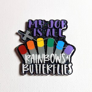May include: A black glitter background with a rainbow of test tubes and the text "My job is all rainbows & butterflies".
