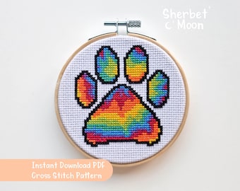 May include: A rainbow tie-dye paw print cross stitch pattern in a wooden embroidery hoop. Instant Download PDF Cross Stitch Pattern.