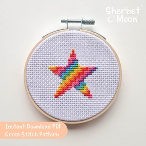 Puede incluir: Un patrón de punto de cruz de estrella arcoíris en un aro de bordado de madera. El patrón se titula "Sherbet Moon" y está disponible como PDF de descarga instantánea.