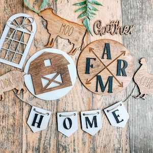 May include: Wooden farmhouse decor with a variety of shapes and sizes. The decor includes a barn, a window, a cow, a pig, a chicken, and a sign that says "Gather Around Farm".