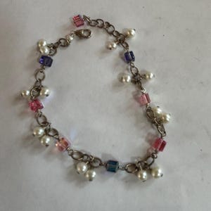 Lieve zilverkleurige schakelarmband met nepparels en roze en paarse vierkante stenen