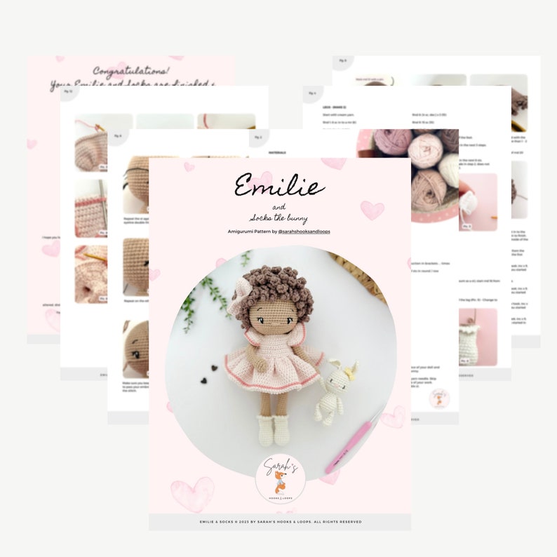 May include: A crochet amigurumi pattern for a doll named Emilie and a bunny. The pattern is printed on pink paper with hearts and includes instructions for making the doll and bunny. The doll has brown curly hair, a pink dress, and white shoes. The bunny is white with pink ears and a pink nose.