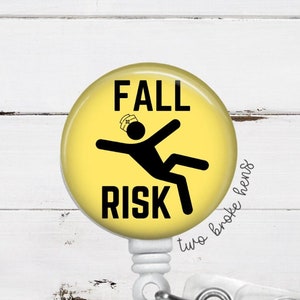 May include: Yellow round badge with a black stick figure falling down and the text "FALL RISK". The badge is attached to a white retractable badge holder.