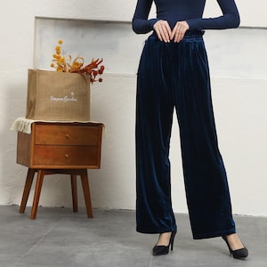 May include: A pair of dark blue velvet wide-leg pants. The pants have a high waist and a relaxed fit.