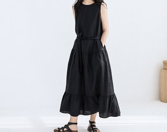 May include: A black sleeveless maxi dress with a tiered skirt and a matching fabric belt. The dress has a simple, elegant design.