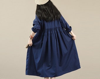 May include: A navy blue long-sleeved dress with a gathered waist and a slightly flared skirt. The dress is made of a lightweight fabric and has a relaxed fit.