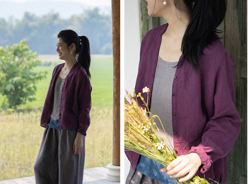 May include: A woman wearing a purple linen cardigan with a button-up front. The cardigan has long sleeves and a relaxed fit. The woman is standing in a field with a bouquet of flowers in her hand.