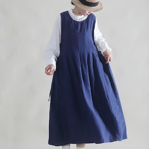 Puede incluir: Un vestido de lino azul marino con un dise&ntilde;o sin mangas y una falda plisada. El vestido tiene un estilo sencillo y casual, perfecto para el clima c&aacute;lido.