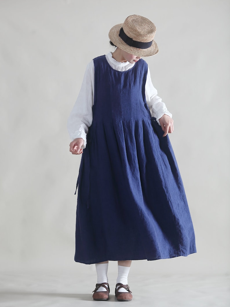 Puede incluir: Un vestido de lino azul marino con un dise&ntilde;o sin mangas y una falda plisada. El vestido tiene un estilo sencillo y casual, perfecto para el clima c&aacute;lido.
