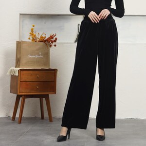 May include: Black wide-leg velvet pants with a high waist and a relaxed fit.