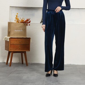 May include: A pair of dark blue velvet wide-leg pants with a gathered elastic waistband.