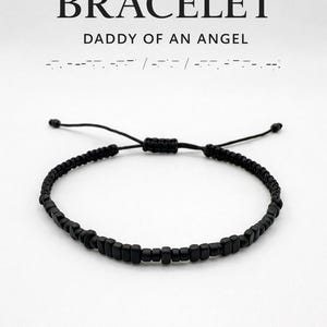 May include: Black beaded Morse code bracelet with the text "MORSE CODE BRACELET" and "DADDY OF AN ANGEL". The bracelet is adjustable and has a minimal design. The hidden message is spelled out in Morse code.