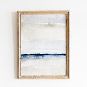 May include: A framed abstract watercolor painting with a light blue and gray color scheme. The painting features horizontal lines and a subtle texture.