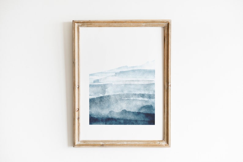 May include: A framed abstract watercolor painting with a blue and white color scheme. The painting features a series of horizontal brushstrokes that create a layered effect.