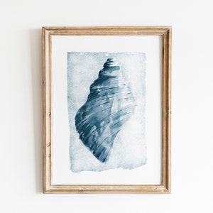 May include: A framed watercolor painting of a blue seashell on a white background.