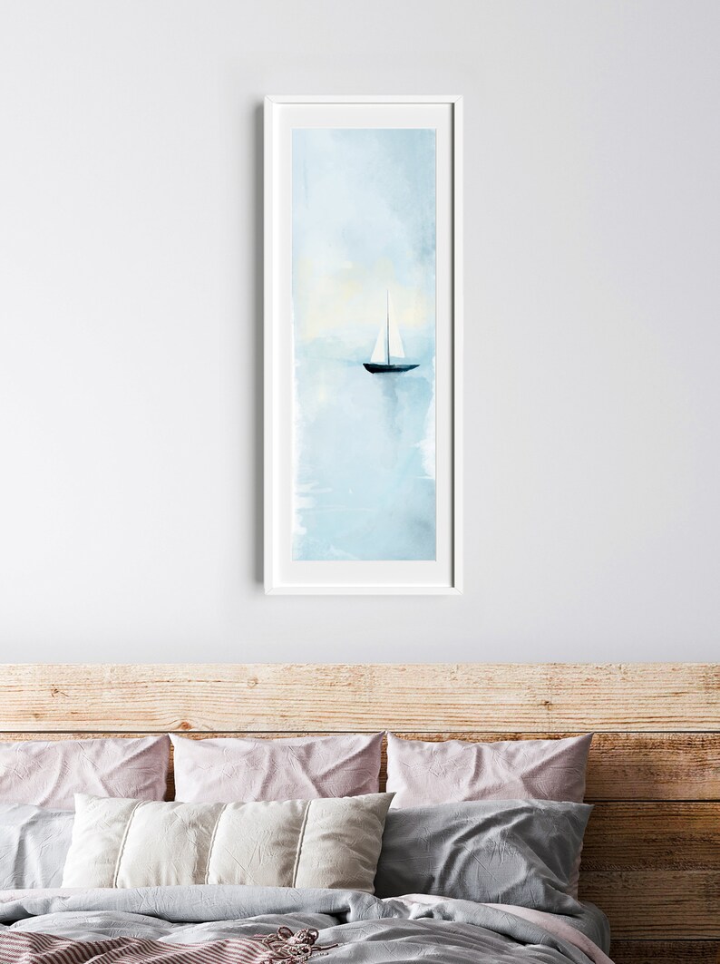 Peut inclure: Une peinture &agrave; l'aquarelle encadr&eacute;e d'un voilier sur une mer bleue calme. Le ciel est bleu clair avec des touches de nuages blancs. Le voilier est blanc avec une coque noire.